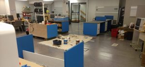 Interior of Catalyst Space during its setup phase, featuring workbenches, 3D printers, and various tools scattered around an open workshop area